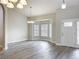 Bright, open living room featuring sleek gray floors, a bay window, and elegant chandeliers at 404 Wilshire Dr, Casselberry, FL 32707