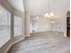 Open living area with gray floors, large windows, and stylish chandelier lighting at 404 Wilshire Dr, Casselberry, FL 32707