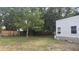 Spacious backyard with mature trees, a small wood fence and partial brick house at 412 Bay Nw St, Fort Meade, FL 33841