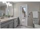 Bathroom featuring a double vanity, toilet, towel rack, and walk out access to patio at 4161 Leafy Glade Pl, Casselberry, FL 32707