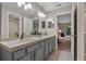 Bathroom featuring dual sinks, neutral tile, and an open doorway to a bedroom at 4161 Leafy Glade Pl, Casselberry, FL 32707