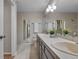 Bright bathroom with dual sink vanity, white countertops, and a tiled shower at 4161 Leafy Glade Pl, Casselberry, FL 32707