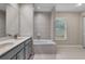 Bright bathroom featuring double sinks, a bathtub with shower, and tile floors at 4161 Leafy Glade Pl, Casselberry, FL 32707