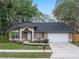 Charming one-story home featuring a two-car garage and a beautifully landscaped front yard with mature trees at 4161 Leafy Glade Pl, Casselberry, FL 32707