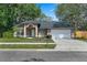 Beautiful one-story home with a two-car garage, lush lawn, and charming landscaping showcasing curb appeal and comfort at 4161 Leafy Glade Pl, Casselberry, FL 32707