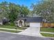 Inviting one-story home showcasing a well-maintained lawn, mature trees and a driveway leading to a two-car garage at 4161 Leafy Glade Pl, Casselberry, FL 32707