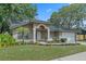 Charming one-story home featuring a well-manicured lawn, mature trees, and welcoming front porch at 4161 Leafy Glade Pl, Casselberry, FL 32707