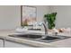 Close-up of kitchen sink with modern faucet, neutral countertop, and decor at 4161 Leafy Glade Pl, Casselberry, FL 32707