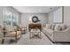 Bright living room featuring neutral tones, stylish furniture, and ample natural light streaming through the large window at 4161 Leafy Glade Pl, Casselberry, FL 32707