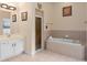 Bright bathroom featuring a shower, soaking tub, vanity, and decorative art for a peaceful ambiance at 426 Vista Loop, Davenport, FL 33897