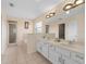 Bright bathroom features double sinks, a large mirror, a tub, and a glass-enclosed shower at 426 Vista Loop, Davenport, FL 33897