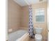 Tiled bathroom with a tub/shower combo, a neutral-colored curtain, and a window for natural light at 426 Vista Loop, Davenport, FL 33897