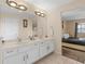 Bathroom featuring a double sink vanity with a large mirror and a glimpse of the bedroom at 426 Vista Loop, Davenport, FL 33897