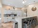 Well-lit kitchen features a breakfast bar with modern stools, white cabinets, and tile floors at 426 Vista Loop, Davenport, FL 33897