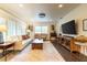 Bright living room with white sofa, wooden coffee table, and large television at 446 Piney Croft Ln, Maitland, FL 32751