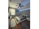 Modern bedroom features hardwood flooring, ceiling fan and soft color scheme at 447 Cadiz Loop, Davenport, FL 33837