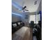 Bonus room features a ceiling fan, dark sofa seating, and a faux fur area rug at 447 Cadiz Loop, Davenport, FL 33837
