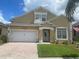 Charming two-story home with a well-maintained lawn, brick paved driveway, and an attached two-car garage at 447 Cadiz Loop, Davenport, FL 33837