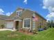 Charming two-story home with a well-maintained lawn, brick paved driveway, and an attached two-car garage at 447 Cadiz Loop, Davenport, FL 33837