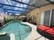 Enjoy this covered pool area, featuring a tanning bed and a sliding glass door to the home's interior at 447 Cadiz Loop, Davenport, FL 33837