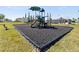 Community playground with a slide, climbing structure, and swing, surrounded by a black rubber surface at 4997 Kaia Ave, Winter Haven, FL 33884