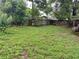 A sprawling backyard, partially shaded by mature trees, enclosed by a wooden fence at 5123 Turnbull Dr, Orlando, FL 32812
