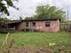 A brick house exterior in a green backyard with mature trees at 5123 Turnbull Dr, Orlando, FL 32812
