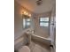 A classic bathroom with tile surround, pedestal sink, and a window providing natural light at 5123 Turnbull Dr, Orlando, FL 32812