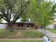 Charming brick home featuring a fenced front yard and mature trees offering shade at 5123 Turnbull Dr, Orlando, FL 32812