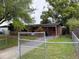 A brick house featuring a front yard enclosed by a chain link fence at 5123 Turnbull Dr, Orlando, FL 32812