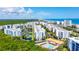 An aerial view showcases condo buildings with beach access and a community pool at 5300 S Atlantic Ave # 6-502, New Smyrna Beach, FL 32169