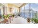 Relaxing screened balcony with seating, tile floor, and coastal-themed decor offers a charming outdoor living space at 5300 S Atlantic Ave # 6-502, New Smyrna Beach, FL 32169