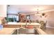 Bright kitchen featuring stainless steel sink, and an open floor plan to the living and dining area at 5300 S Atlantic Ave # 6-502, New Smyrna Beach, FL 32169