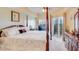 Spacious main bedroom featuring a four-poster bed, ceiling fan, and balcony access for a luxurious retreat at 5300 S Atlantic Ave # 6-502, New Smyrna Beach, FL 32169