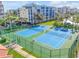 Well-maintained tennis courts in a community setting with lush landscaping and nearby condo buildings at 5300 S Atlantic Ave # 6-502, New Smyrna Beach, FL 32169