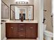 Bathroom featuring a double vanity with dark wood cabinets and a large mirror at 5464 Factors Walk Dr, Sanford, FL 32771