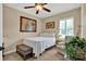 Cozy bedroom features a comfortable bed, sitting area, and a large window with plantation shutters at 5464 Factors Walk Dr, Sanford, FL 32771