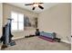 Carpeted exercise room featuring a ceiling fan, workout equipment, neutral walls, and a window with shutter blinds at 5464 Factors Walk Dr, Sanford, FL 32771