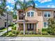 Inviting two-story townhome with a charming front porch and lush landscaping at 5464 Factors Walk Dr, Sanford, FL 32771