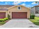 Exterior view of the attached two-car garage with a paved driveway and manicured landscaping at 5464 Factors Walk Dr, Sanford, FL 32771