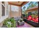 Cozy screened patio with comfortable seating, a patterned rug, decorative plants, and outdoor views at 5464 Factors Walk Dr, Sanford, FL 32771