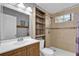 Bright bathroom with shower, tiled wall detail, and built-in shelving unit for storage space at 5750 Delta St, Orlando, FL 32807