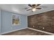 Comfortable bedroom with wood-look flooring, wood accent wall, and a bright window at 5750 Delta St, Orlando, FL 32807