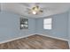Serene bedroom features wood-look flooring, a ceiling fan, and natural light from two windows at 5750 Delta St, Orlando, FL 32807