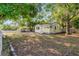Charming yellow cottage-style home with lush trees and a white picket fence at 5750 Delta St, Orlando, FL 32807