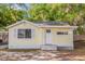 Adorable yellow cottage-style home with a white front door and well-maintained yard at 5750 Delta St, Orlando, FL 32807