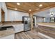 Bright kitchen features a stainless refrigerator, white cabinets, and wood plank ceiling at 5750 Delta St, Orlando, FL 32807