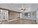 Inviting living room with wood accent wall, wood-look floors, and ceiling fan at 5750 Delta St, Orlando, FL 32807