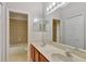 A well-lit bathroom featuring double sinks, a large mirror, and tiled floors at 626 Green Rock Ct, Apopka, FL 32712