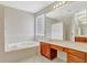 Bright bathroom featuring a soaking tub, glass block window and vanity with cabinets at 626 Green Rock Ct, Apopka, FL 32712